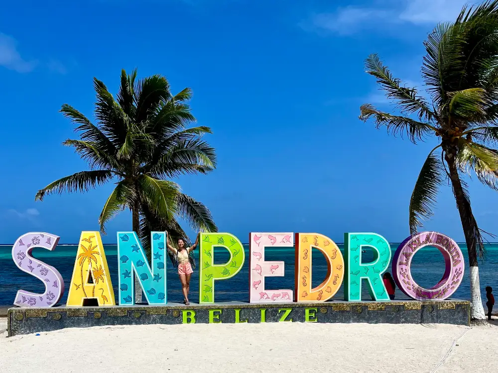 A big, tourist, colorful that says "San Pedro" with palm trees and oceans in the background.