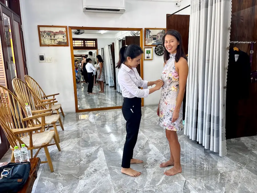 A woman fixing the waist of the blog author's dress.